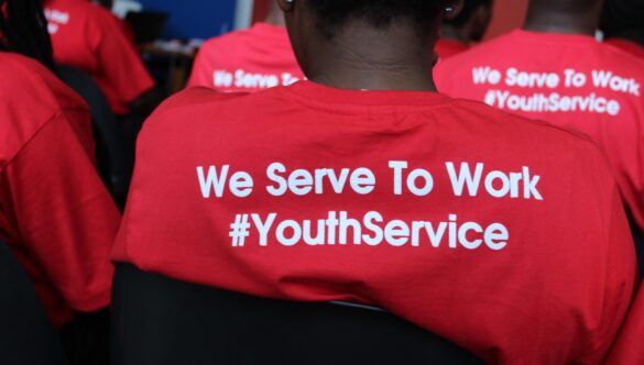 Back of a service leader t-shirt that says: We Serve To Work #YouthService